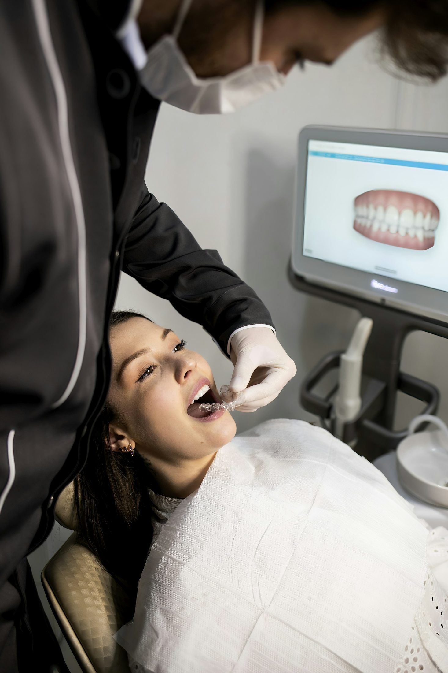Zahnärztin scannt die Zähne einer Patientin mit einem Intraoralscanner
