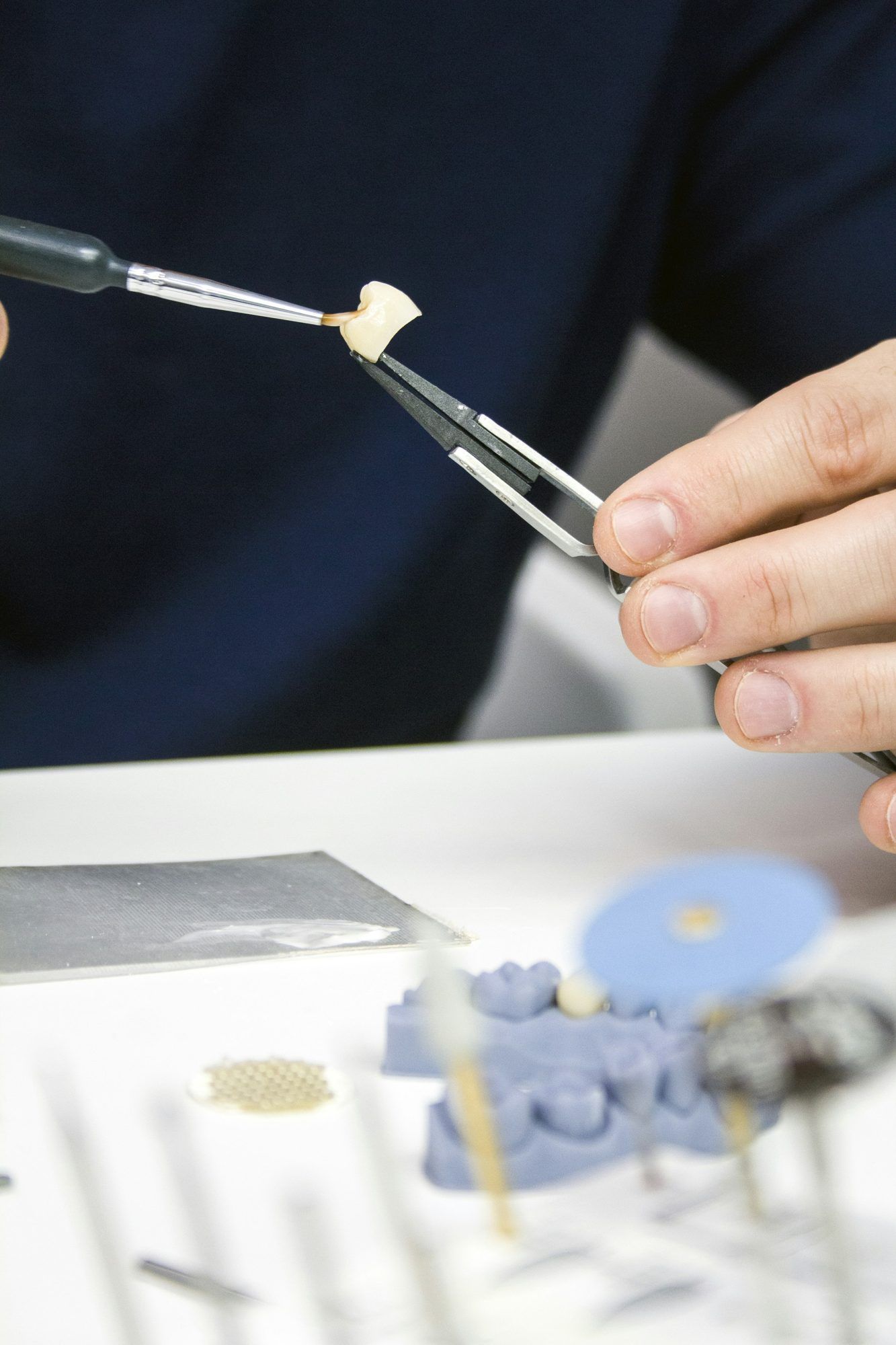 Zahntechniker schichtet Keramik mit Pinsel